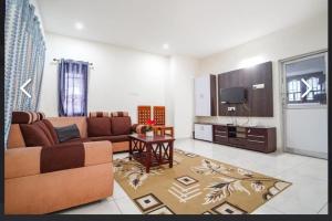 a living room with a couch and a tv at SS Holiday Homes in Yenūr