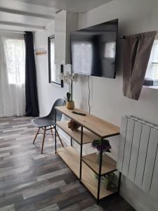 a living room with a desk and a television on the wall at location dreux in Dreux