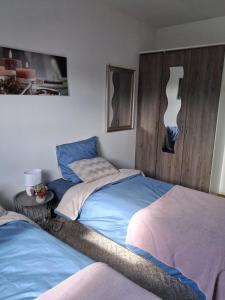a bedroom with two twin beds and a wooden headboard at location dreux in Dreux