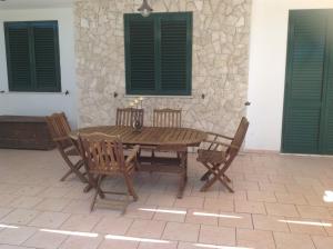 einen Holztisch und Stühle auf einer Terrasse in der Unterkunft Sole Luna in Castro di Lecce