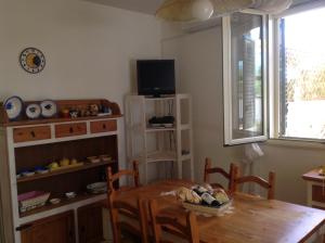 ein Esszimmer mit einem Holztisch und einem TV in der Unterkunft Sole Luna in Castro di Lecce