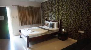 una camera con un letto in una stanza con carta da parati di The Park Nangrong Resort a Nang Rong