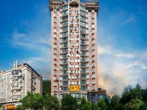 a tall apartment building with a fire in the background at Super 8 Hotel Shiyan Beijing Middle Road in Shiyan