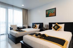 Una habitación de hotel con dos camas y una ventana. en Hoang Long Hotel Phan Thiết, en Phan Thiet 116 fotos más