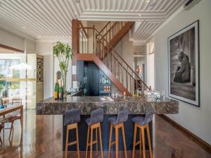 a kitchen with a bar with blue bar stools at Zank by Toque Hotel in Salvador