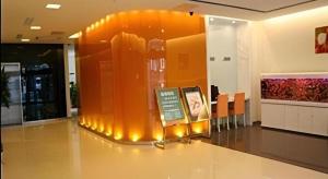 a lobby with an orange wall with a sign in it at Jinjiang Inn Qingdao Development Zone Jinggangshan Rd. in Huangdao