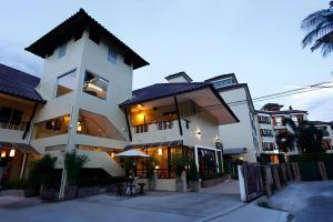 un gran edificio blanco con una sombrilla delante en The Xym Hotel, en Chiang Mai