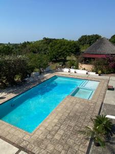una piscina con agua azul en un resort en Beautiful traditional style studio, en Maputo