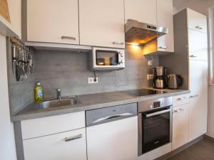 a kitchen with white cabinets and a sink and a microwave at Apartment near the ski slope in Brixen in Feuring +33 photos