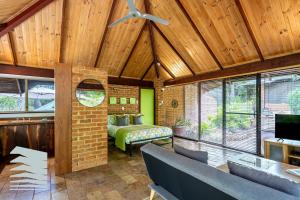 Una sala de estar con una cama y un ventilador de techo. en Dunsborough Ridge Retreat, en Dunsborough