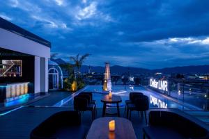 a rooftop bar with a view of the city at night at Shanyujin Dellar Wild Luxury Hotel Luxury Mountain Retreat in Lijiang