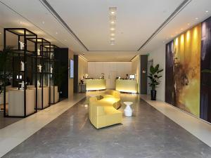 a lobby with a yellow couch and a yellow chair at Jinjiang Metropolo Shanghai Xujiahui Nanhuating Hotel in Shanghai