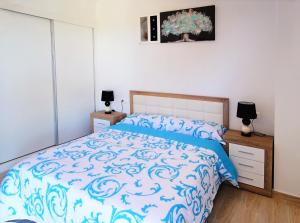 Schlafzimmer mit einem Bett mit blauer Decke in der Unterkunft Pinada La Mata in La Mata