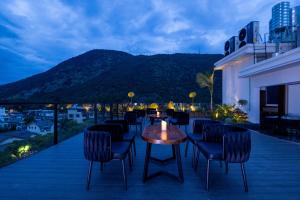 a patio with chairs and a table and a mountain at Shanyujin Dellar Wild Luxury Hotel Luxury Mountain Retreat in Lijiang