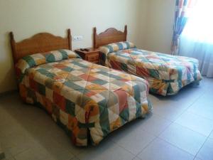 two beds sitting next to each other in a room at Hostal Carmen in El Puente +17 photos