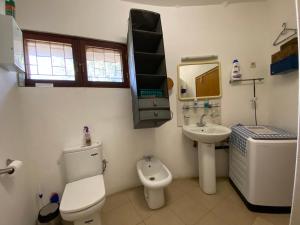 Un baño con inodoro, lavabo y espejo. en Beautiful traditional style studio, en Maputo 10 fotos más