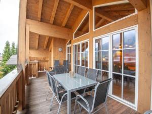 a dining room with a table and chairs on a porch at Luxury penthouse with Balcony Ski Storage Carport Lift in Brixen im Thale