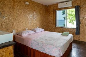 a bedroom with a large bed with a window at Parinya Hill Homestay & Cafe Koh Larn in Ko Larn +13 photos