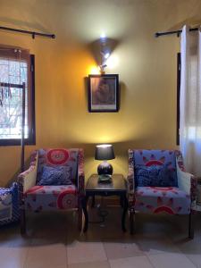Una sala de estar con dos sillas y una lámpara sobre una mesa. en Beautiful traditional style studio, en Maputo
