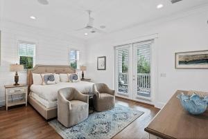a bedroom with a bed and two chairs and a table at Mermaid Cove in Inlet Beach +55 photos