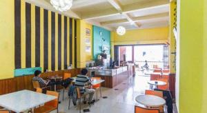 two young boys sitting at tables in a restaurant at Hotel O Pondok Ripuji in Sungguminasa
