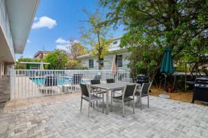 a patio with a table and chairs and an umbrella at Olde Naples Paradise 803 in Naples