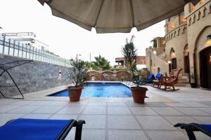 an outdoor patio with a swimming pool and an umbrella at Villa Nur in Luxor