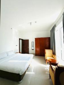 アブダビにあるRiver & Sky Homes 6003の大きなベッドと椅子のある寝室