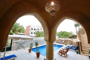 a view of a swimming pool from a building with arches at Villa Nur in Luxor