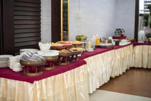 a long table with plates and bowls of food on it at PhoomThai Garden Hotel in Phrae