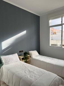 two beds in a bedroom with a window at Charming apartment heart of Medina Tetouan 2BR in Tetouan