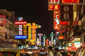 een drukke stadsstraat 's nachts met neonborden bij XX Mitr Inn Yaowarat - มิตร อินน์ เยาวราช in Khlong San