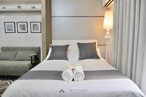 Una habitación de hotel con una cama con toallas. en The Cavana Suites, en Pusok
