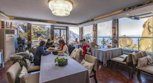 un grupo de personas sentadas en mesas en un restaurante en Huangshan Yupinglou Hotel, en Beihaibinguan