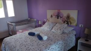 Dormitorio púrpura con cama con almohadas azules en Orzola Para Descansar, en Orzola