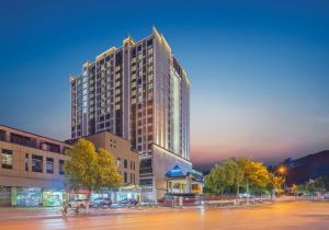 Un edificio alto en una calle de la ciudad por la noche. en Home2 Suites by Hilton Zhangjiajie Tianmen Mountain, en Zhangjiajie 4 fotos más