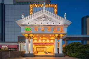 a large building with lights on it in front of a building at Vienna Hotel Shenzhen International Exhibition Center Fuhai Qiaotou in Shenzhen