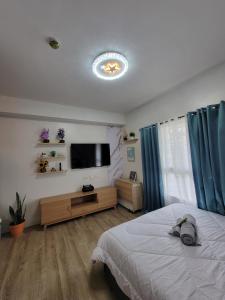 Un dormitorio con una cama y un televisor de pantalla plana. en Dylan's Crib, en Bacolod