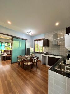 バーン・クロンムアンにあるSmile Home Krabi Klong Moung Beachのテーブルと椅子のあるキッチンとリビングルーム
