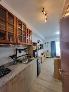 Una cocina con gabinetes de madera y encimera. en Dylan's Crib, en Bacolod