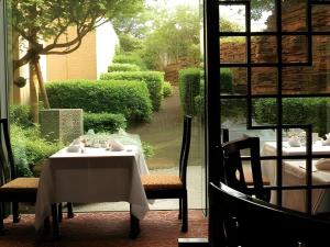 a dining room with a table and a view of a garden at Gunma Royal Hotel in Maebashi