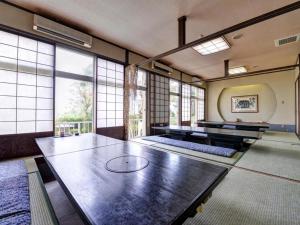 南知多町にあるHotel Himakasouのテーブルと大きな窓が備わる広い客室です。
