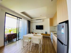 a kitchen and dining room with a table and chairs at Aristo 2 Condo with a sea view in Ban Lum Fuang