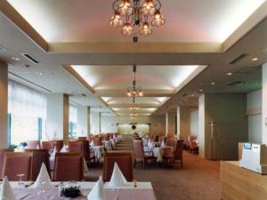 une salle à manger avec tables et chaises et un lustre dans l'établissement Washigatake Kogen Hotel Rainbow, à Seki