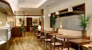 a restaurant with wooden tables and chairs and plants at Ako Royal Hotel in Nakahiro