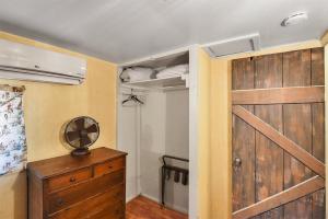 1 dormitorio con armario y puerta de madera en Rustic Adventure w Historic Log Cabin Forest Views 20 minutes from Flagstaff Now with Wi-Fi, en Parks