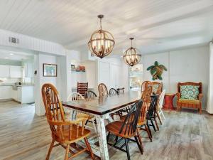 Un comedor con mesa y sillas de madera. en Coast A While, en Tybee Island