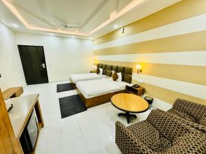a room with a bed and a table and chairs at Murthal Green Plaza Hotel in Sonīpat