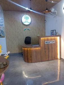a reception desk in a room with a sign on the wall at Murthal Green Plaza Hotel in Sonīpat