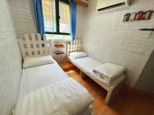 香港にあるCozy Inn Jordan Stationのベッドが2つと窓がある小さな部屋